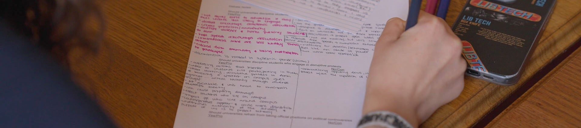 a student writing note at debate across the curriculum