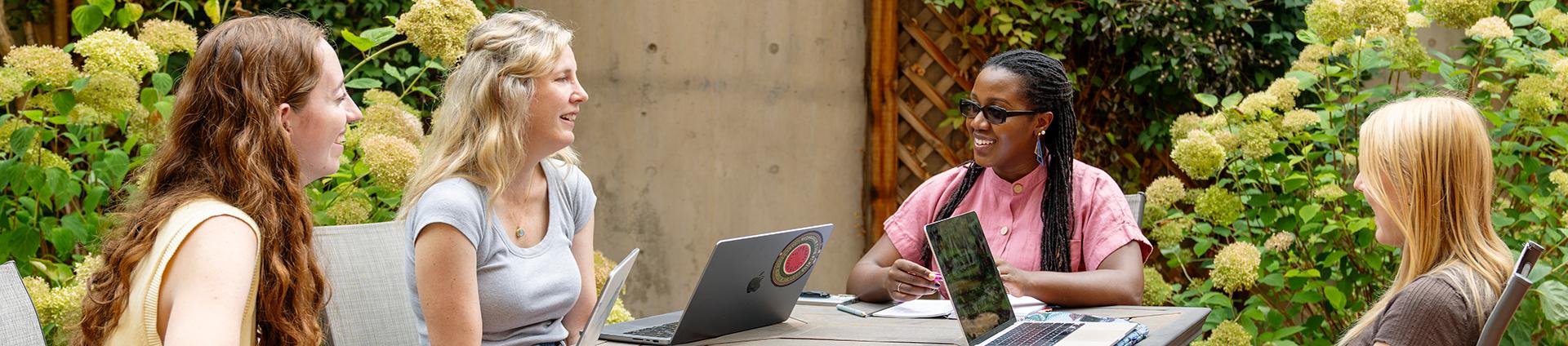 four people sitting around the table and discussing