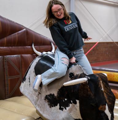 student on mechanical bull at tailgate party