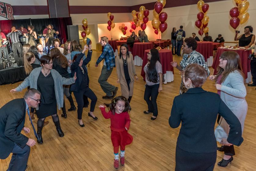 Child dancing on the floor with adults